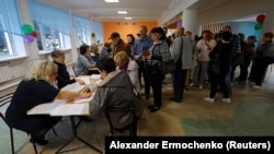 People receive their ballots at a polling station during a referendum on Ukraine's Donetsk region joining Russia in Donetsk on September 27.