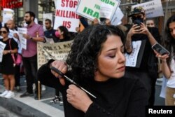 Žena siječe kosu u znak protesta nakon smrti Mahse Amini, New York, 27. septembar 2022.