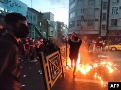 O fotografie realizată de AFP îi arată pe iranienii ieșiți în stradă pe 21 septembrie 2022 pentru a protesta împotriva morții Mahsei Amini și a suprimării drepturilor și libertăților omului din țară.