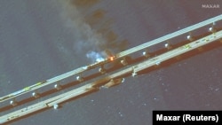 На цветном инфракрасном спутниковом снимке крупным планом виден дым, поднимающийся от пожара на Керченском мосту в Керченском проливе, Крым, 8 октября 2022 года.