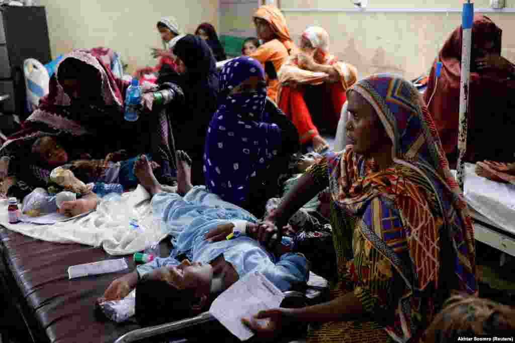 Жени погодени од поплавите седат со своите деца кои боледуваат од маларија и треска додека добиваат медицинска помош. Една од најтешките хуманитарни катастрофи во Пакистан, поврзани со климатските промени, започна пред повеќе од три месеци со катастрофални поплави. Со својата економија во криза и поддржана од заеми од Меѓународниот монетарен фонд, Пакистан нема ресурси за да се справи со долгорочните ефекти од поплавите.
