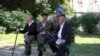 Sarajevo, Bosnia and Herzegovina -- A group of retirees sitting on a bench in a park