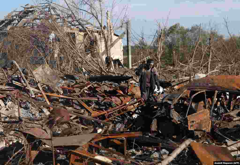 A man walks through the wreckage of his home and car.&nbsp; The city&#39;s residents, some of whom were put on the Russian payroll during occupation, are now subjected to an unrelenting onslaught of aerial bombardment.