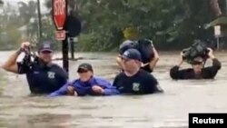 Zjarrfikësit duke tentuar të shpëtojnë një grua në Florida.