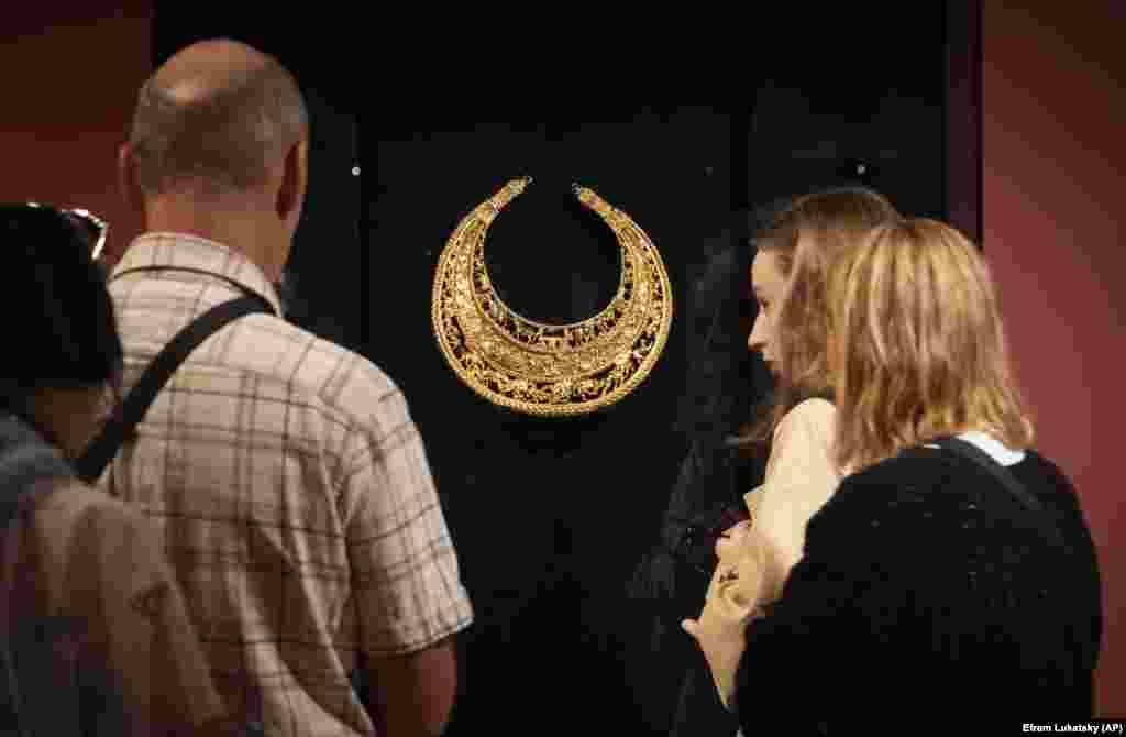 Visitors look at a replica of the fourth-century B.C. golden pectoral, an ancient treasure from a Scythian king&#39;s burial mound, exhibited in the Museum of Historical Treasures in Kyiv. Tkachenko said the&nbsp;looting and destruction of cultural sites has caused losses estimated in the hundreds of millions of dollars. &quot;The attitude of Russians toward Ukrainian culture heritage is a war crime,&quot; Tkachenko told AP.&nbsp;