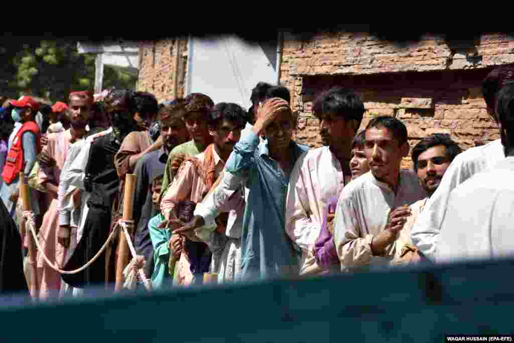 People affected by floods line up to receive free food distributed by the Pakistan Red Crescent Society in Larkana on October 2. The United Nations has warned that about 5.7 million Pakistani flood survivors will face a serious food crisis in the next three months. Even before the floods, 16 percent of the population was living in moderate or severe food insecurity, according to the World Health Organization.