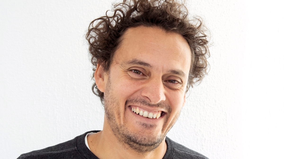 Мъж в доспехи от автомобилни джанти, който гордо е вдигнал