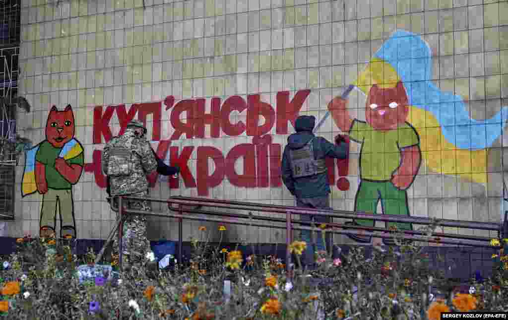 Un grup de grafferi scriu pe zid &bdquo;Kupiansk este Ucraina&rdquo; în orașul eliberat pe 16 octombrie. Cât timp a ocupat Kupiansk, Moscova a instituit un sistem educațional rusesc, a introdus pașapoarte și a tăiat liniile telefonice și canalele de televiziune ucrainene - izolând, practic, orașul. &nbsp;