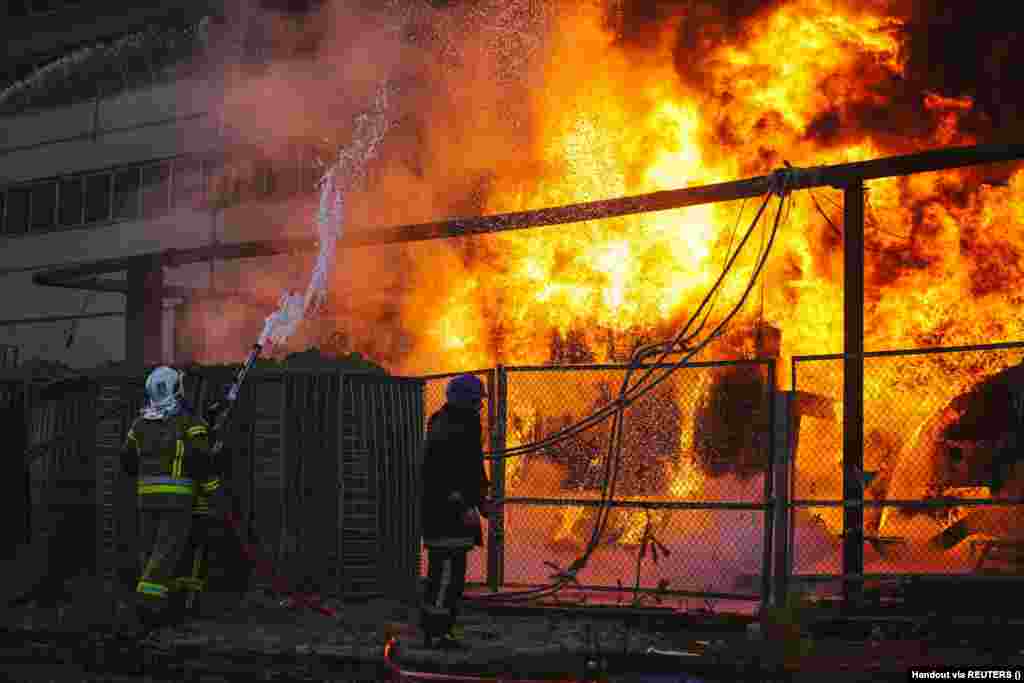 Firefighters work to put out a fire at a thermal power plant damaged by a Russian missile strike in Kyiv on October 18. Russia has repeatedly targeted civilian and infrastructure targets across Ukraine resulting in electricity being cut in more than 1,000 cities, towns, and villages. &nbsp;