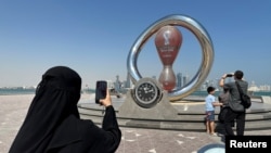Egy nő fotózza a katari vb-visszaszámláló órát Dohában