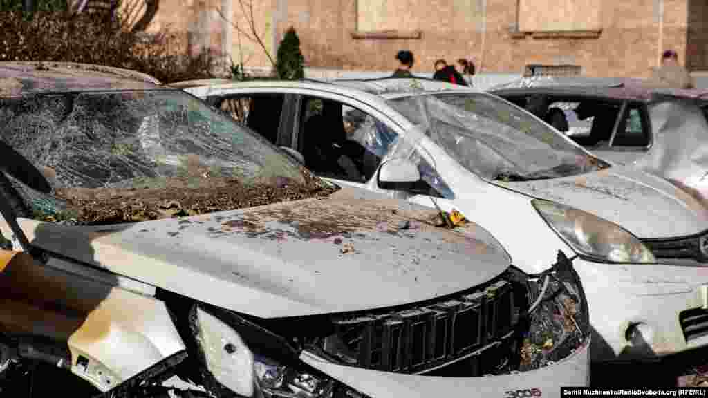 Пошкодженні автівки у дворі житлового будинку, який потрапив під ракетний обстріл 10 жовтня 2022 року