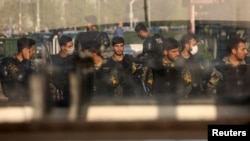 Iranian security forces stand on a street in Tehran on October 8.