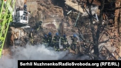 Mentőalakulatok dolgoznak egy találatot kapott épület romjainál Kijevben 2022. október 17-én 