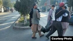 People carry a man wounded in the bombing in Kabul on September 30. 