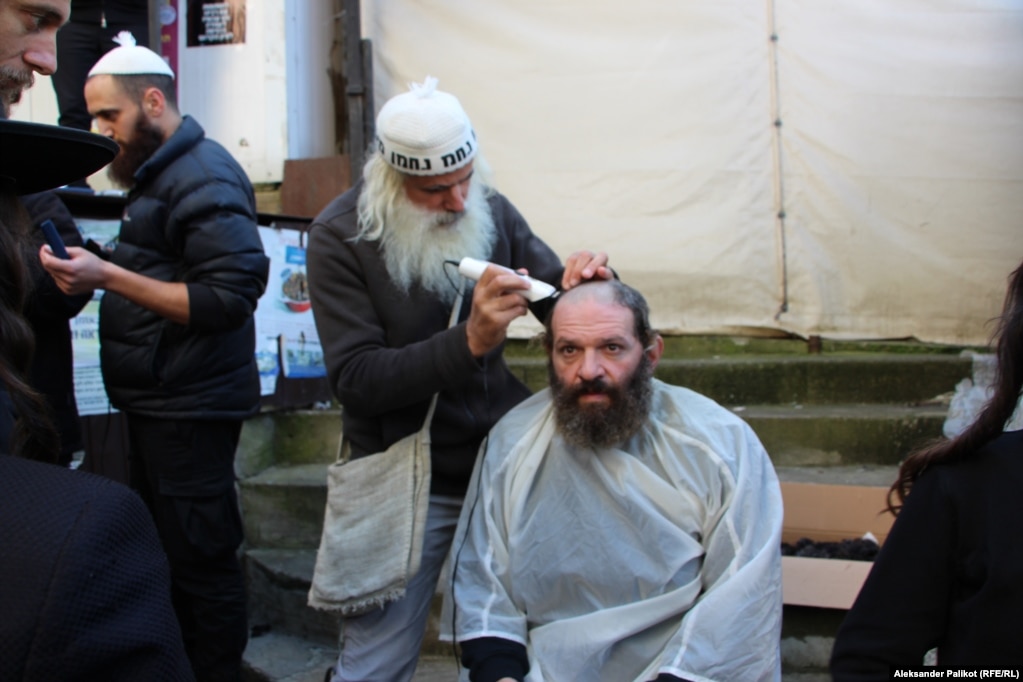 A man gets his hair cut before Rosh Hashanah in Uman. .