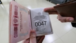 Гражданин России держит паспорт в здании миграционного центра обслуживания населения. Алматы, 3 октября 2022 года