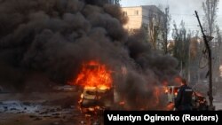 Autók lángolnak Kijev, az ukrán főváros központjában az orosz rakétatámadás után, 2022. október 10-én