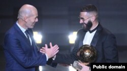 Игрок мадридского "Реала" Карим Бензема получает награду "Золотой мяч" от признанной легенды мирового футбола Зинедина Зидана. 17 октября 2022 года