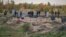 Police and forensics experts examine a mass grave found in the Donetsk region of Ukraine in October 2022.