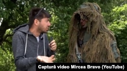 NATO și Parlamentul European au apelat la Mircea Bravo pentru a-și face mai atractivă imaginea în rândul tinerilor. Vlogger-ul, alături de un militar, în timpul unui exercițiu la poligonul de la Cincu, Brașov.