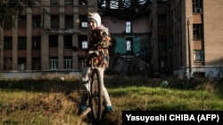 A girl stands in an abandoned playground of her destroyed school in Kostyantynivka in the Donetsk region on October 13.