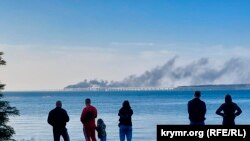 Жители Керчи наблюдают за пожаром на Керченском мосту, 8 октября 2022 года