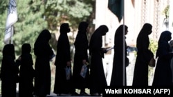 Gratë afgane qëndrojnë në radhë para Universitetit të Kabulit për t'iu nënshtruar testit pranues për në universitet. 13 tetor 2022.