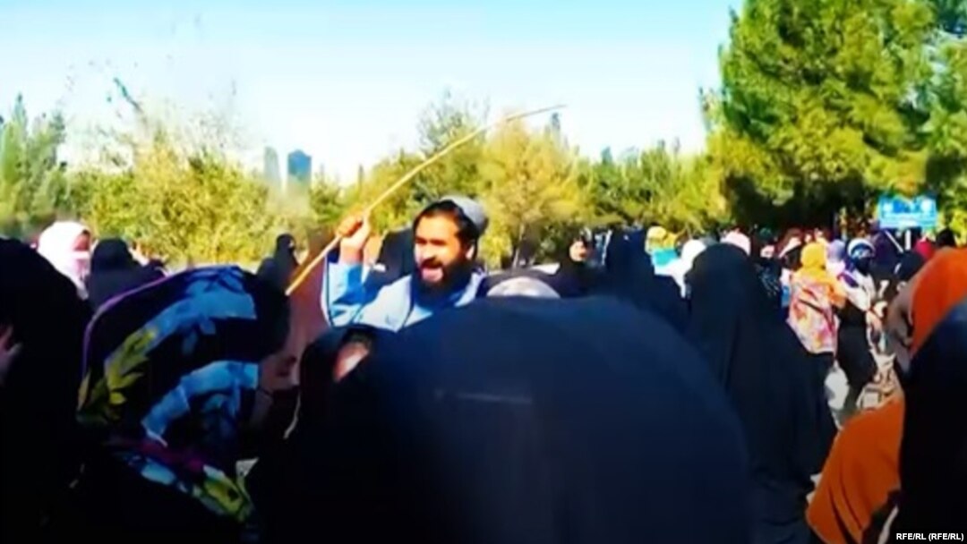 A Taliban fighter tries to disperse a protest by university students in the western Afghan province of Herat.