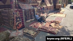 Продавець килимів на блошиному ринку