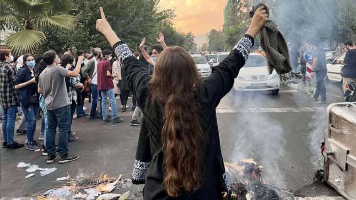A woman holds up her head scarf as part of a protest in Tehran on September 27, 2022, against the death of 22-year-old Mahsa Amini in police custody.