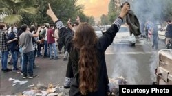 Iran - A woman holds up her headscarf as part of a protest in Tehran on September 27.