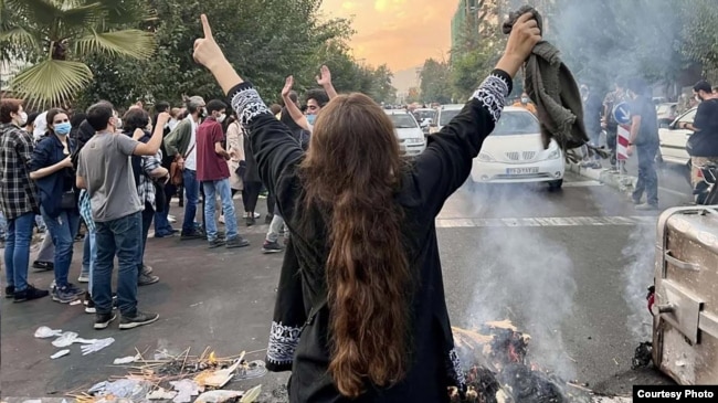 Iran - A woman holds up her headscarf as part of a protest in Tehran on September 27.