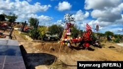 Могила российского военного, убитого в Украине (в центре), на кладбище в Керчи расположена возле мемориала погибшим студентам (слева), Крым, сентябрь 2022 года