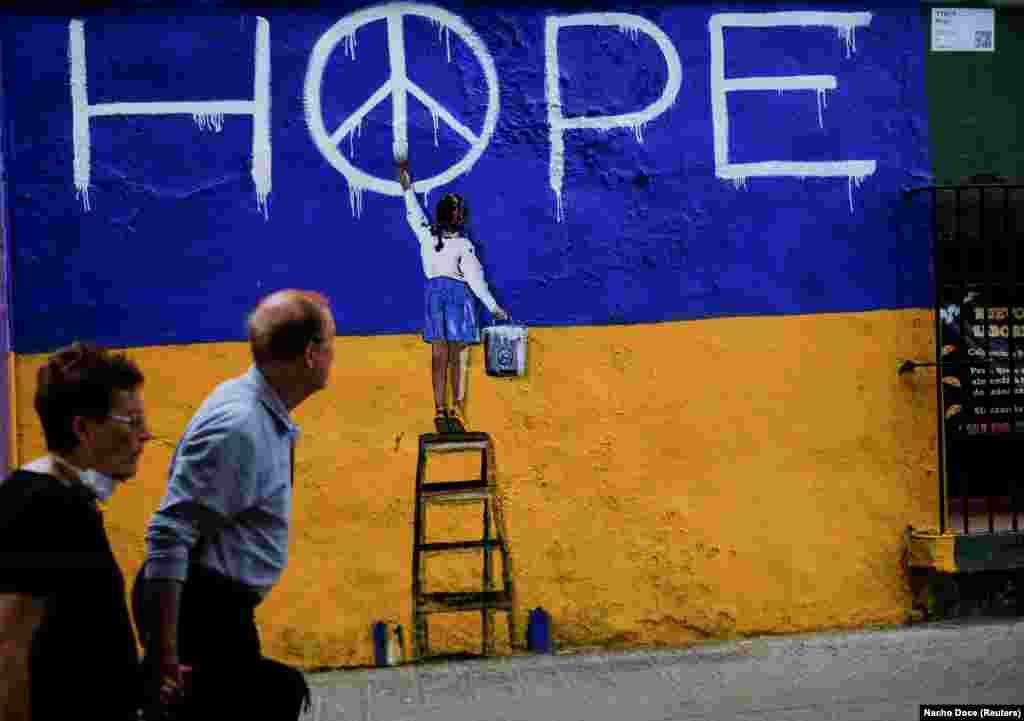 A couple walk past a mural in Barcelona, Spain, on May 9.&nbsp;