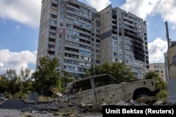 Destroyed buildings and a car in Kharkiv's Saltivka neighborhood