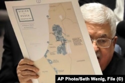 Na fotografiji iz 2020. palestinski predsjednik Mahmoud Abbas drži mapu tražene palestinske države, na sjednici Vijeća sigurnosti UN-a. On je decenijama tražio međunarodnu podršku za nezavisnu palestinsku državu na teritoriji koju je Izrael zauzeo u ratu 1967.