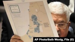Na fotografiji od 11. februara 2020. godine, palestinski predsjednik Mahmoud Abbas drži mapu moguce palestinske države, dok govori tokom sastanka Vijeća sigurnosti u sjedištu UN-a.