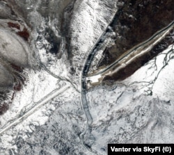 A satellite image captured on October 11 showing the new Afghan road (straight line on left) that runs to within a few dozen meters of the Chinese border. A border fence running north to south is fortified on the Chinese side with razor wire, machine-gun posts and trenches.
