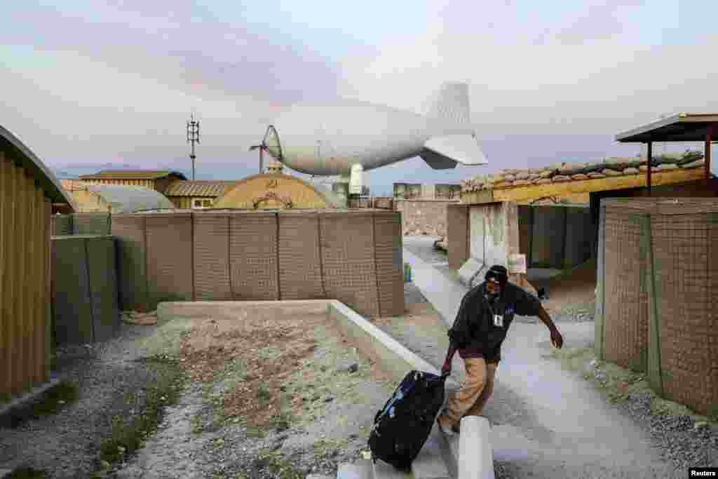 A contractor drags his bag out of a housing complex at Forward Operating Base Gamberi, which remains part of the ongoing Operation Resolute Support in Afghanistan's Laghman Province. (Reuters/Lucas Jackson)