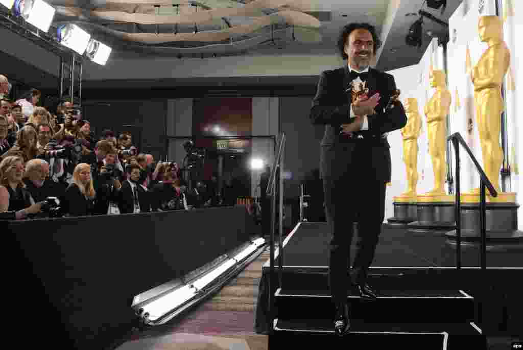 Weighed down with awards - Alejandro G. Inarritu poses with his Academy Awards for Best Picture, Best Director and Best Original Screenplay for Birdman. The film also won the Best Cinematography prize.