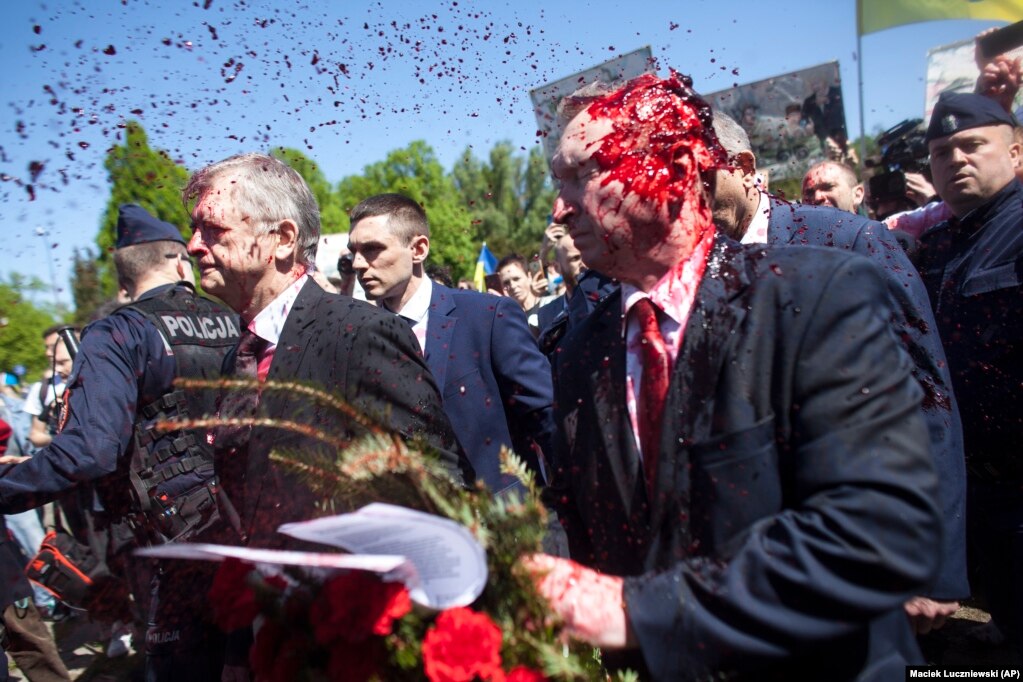 Ndaj ambasadorit rus në Poloni, Sergei Andreyev (djathtas), u gjuajt me ngjyrë të kuqe nga disa protestues kundër pushtimit rus të Ukrainës, derisa ai po tentonte të vendoste lule në një varrezë në Varshavë, më 9 maj.