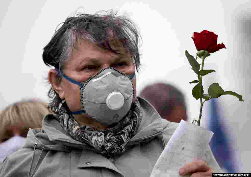 An opposition supporter wearing a face mask attends the rally in Minsk.