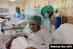 An Afghan doctor checks a COVID-19 patient at the Afghan-Japan Hospital in Kabul in January.