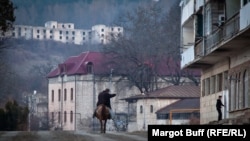 Мужчина верхом на лошади едет по улице в городе Шуша в Нагорном Карабахе.