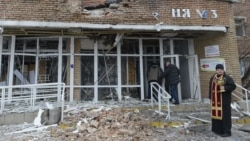 A priest stands in front of a hospital destroyed after shelling between Ukrainian forces and pro-Russian separatists in the eastern city of Donetsk, Ukraine, on January 19.
