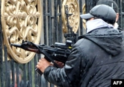 A Kyrgyz opposition supporter fires an automatic weapon near the main government building during a protest against the government in Bishkek in April 2010.