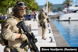 Pripadnici specijalnih snaga vojske Crne Gore u Tivtu pred samit EU-Zapadni Balkan, dok se Vučić u blizini obraća novinarima.