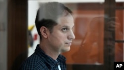 Evan Gershkovich stands in a glass enclosure during a court hearing in Moscow in October.
