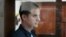 Evan Gershkovich stands in a glass enclosure during a court hearing in Moscow in October.