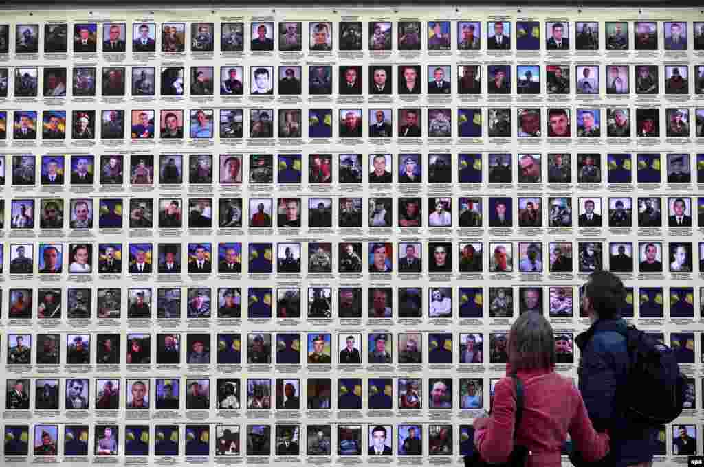 People walk past portraits in Kyiv of Ukrainian soldiers who died in fighting in the country's separatist east between August 23 to October 10, 2014. (epa/Tatyana Zenkovich)